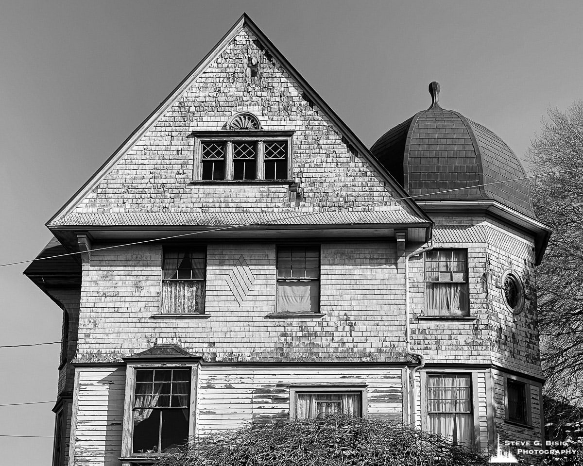 A black and white mobile photograph of an old house in Astoria, Oregon.