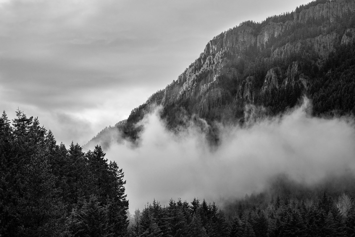 A black and white landscape photograph of evening light shining on the Palisades of Dalles Ridge near Greenwater, Washington.